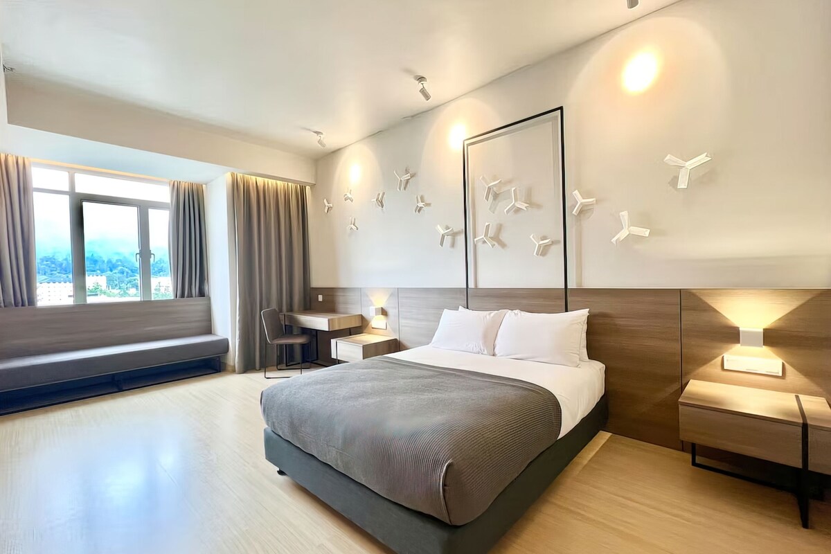 Une chambre d’hôtel moderne avec un grand lit, un bureau et une vue sur la ville.