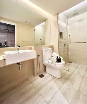 Un baño moderno con un lavabo grande, inodoro y cabina de ducha de vidrio.