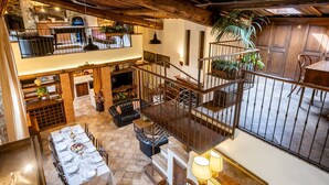 A spacious loft-style living area with a high ceiling, wooden beams, a dining area with a table set for six, and a staircase leading to an upper level. - Beautiful private villa with WIFI, A/C, private pool, TV, veranda and pets allowed, close to Are... (Santa Firmina)