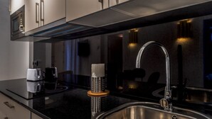 A modern kitchen with a stainless steel sink, a built-in microwave, and a toaster.