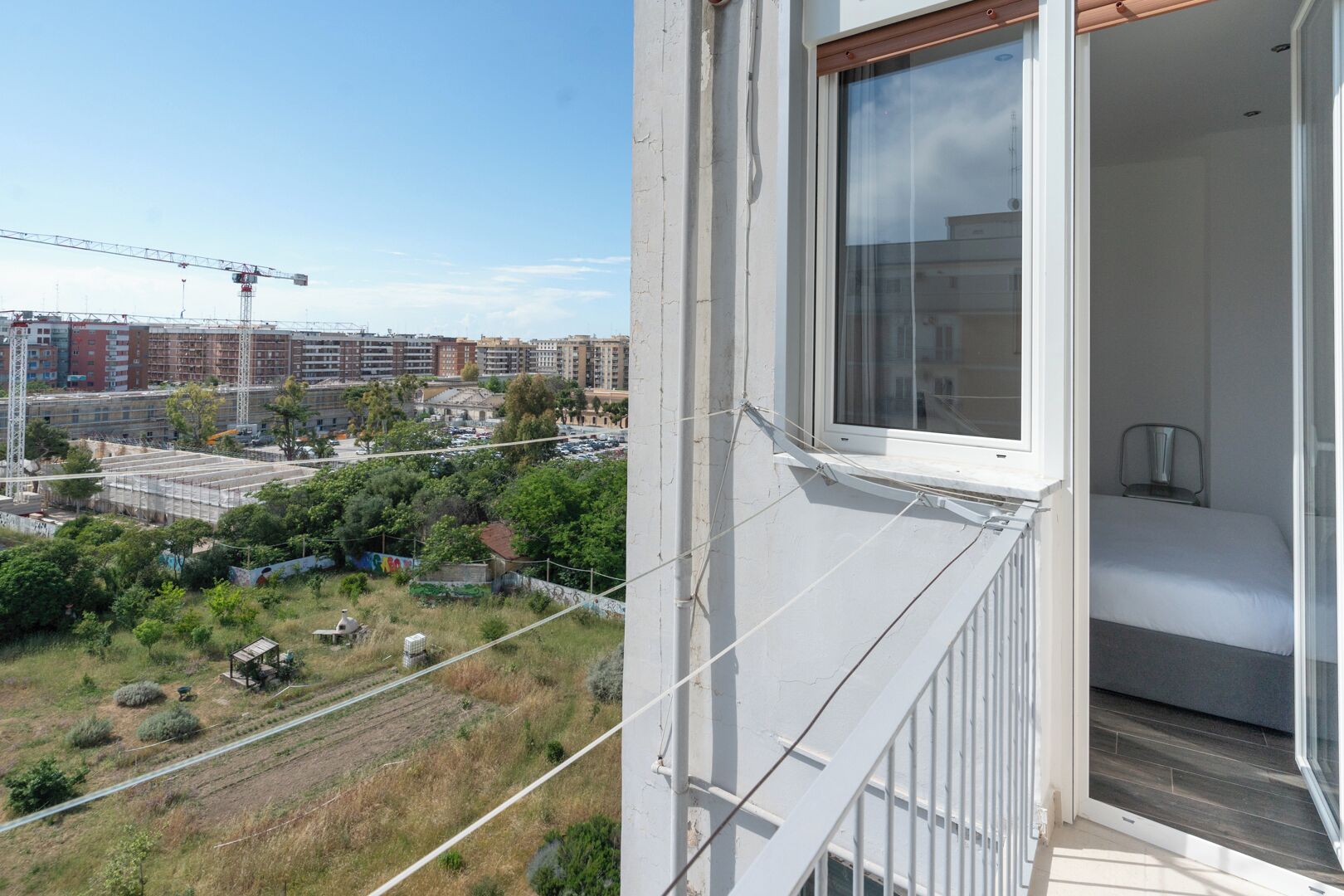 A balcony with a view of a construction site and a residential area.