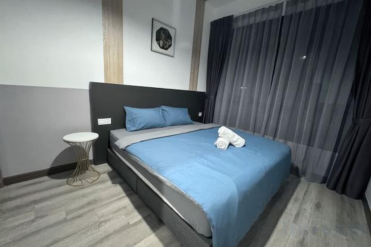 A hotel room with a bed, a round side table, and a headboard.