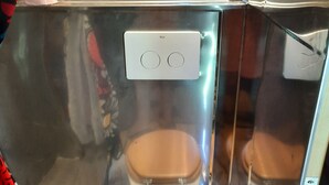 Une salle de bain avec deux toilettes en bois, un miroir et un mur recouvert de panneaux en bois.