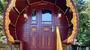 Une voiture richement décorée, immobile, avec une rampe menant à une porte portant l’inscription « la bohémienne ».