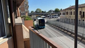 A balcony with a view of a street, including a tram and a bus. - MMM HOME TRAIN STATION 1 (Mestre)
