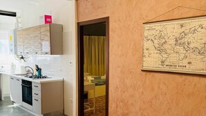 A hotel room with a kitchen area, a map on the wall, and a tiled floor. - MMM HOME TRAIN STATION 1 (Mestre)