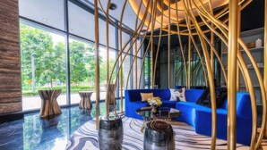 A modern interior with a blue sofa, abstract vases, and a unique ceiling design. - Star Luxury Suites KLCC (Kuala Lumpur)