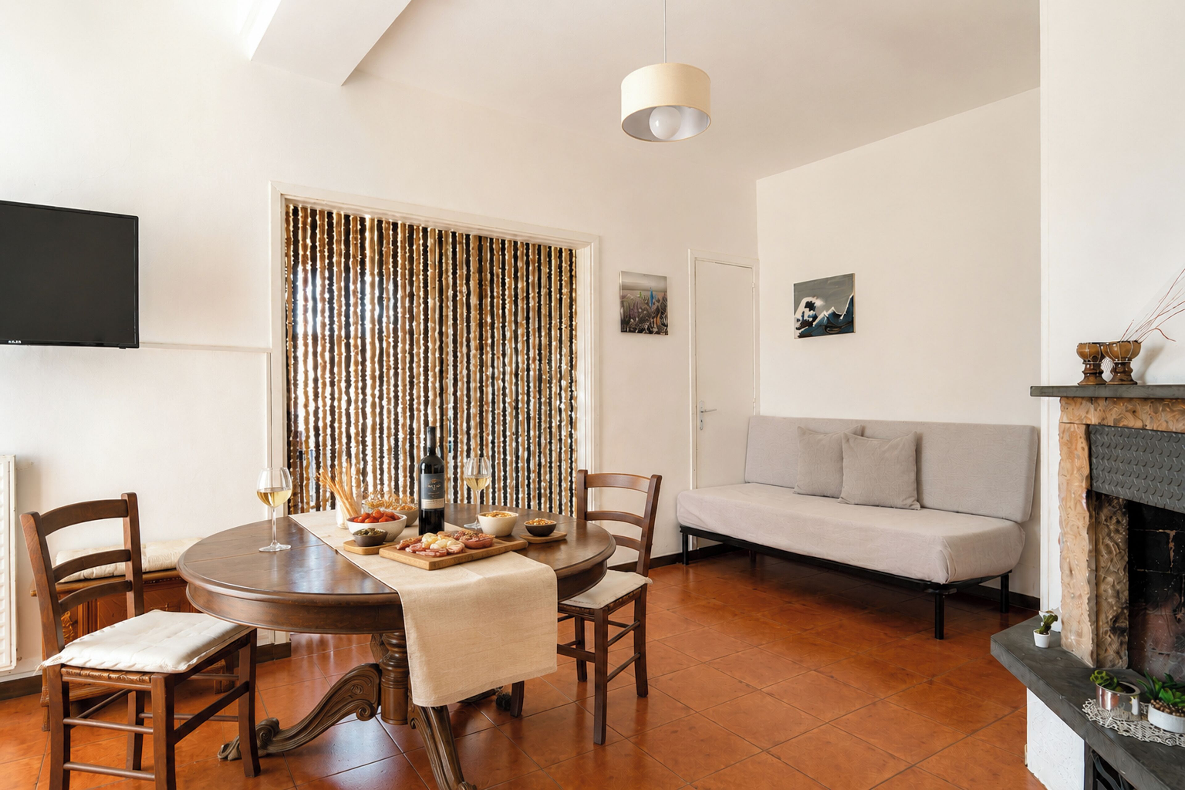 Una sala moderna con una mesa redonda para comer, sillas, un sofá y una chimenea.
