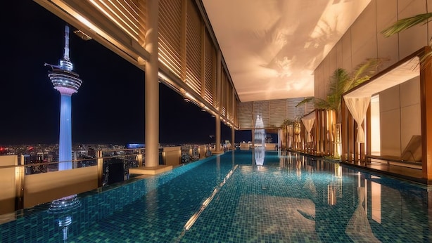 A rooftop infinity pool with a city skyline view, including a prominent tower. - Pavilion Ceylon Hill Suites Apartments KL (Kuala Lumpur)