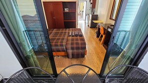 A bedroom with a bed, a wardrobe, a desk, and a chair. - Smyrna (Pattaya)