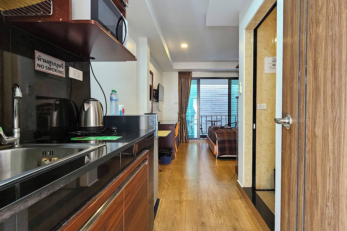 A kitchenette with a 'NO SMOKING' sign, a sink, kettle, and a water bottle.