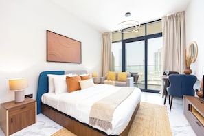 A modern hotel room with a large bed, a desk, a chair, and a view of the city through the window. - Bloomfields Fabulous STU In Al Maryah  (Abu Dhabi)