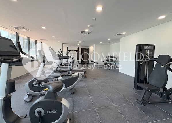 A gym with various exercise equipment including treadmills, a weight machine, and a bench. - Bloomfields Fabulous STU In Al Maryah  (Abu Dhabi)