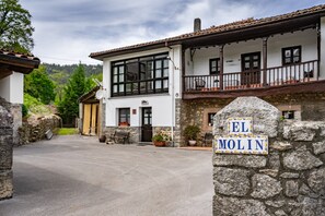 A two-story building with a stone facade, a balcony, and a sign reading 'EL MOLIN'.