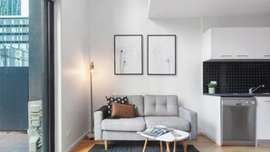 Una sala de estar moderna con un sofá gris, una mesa de centro y dos cuadros enmarcados en la pared.
