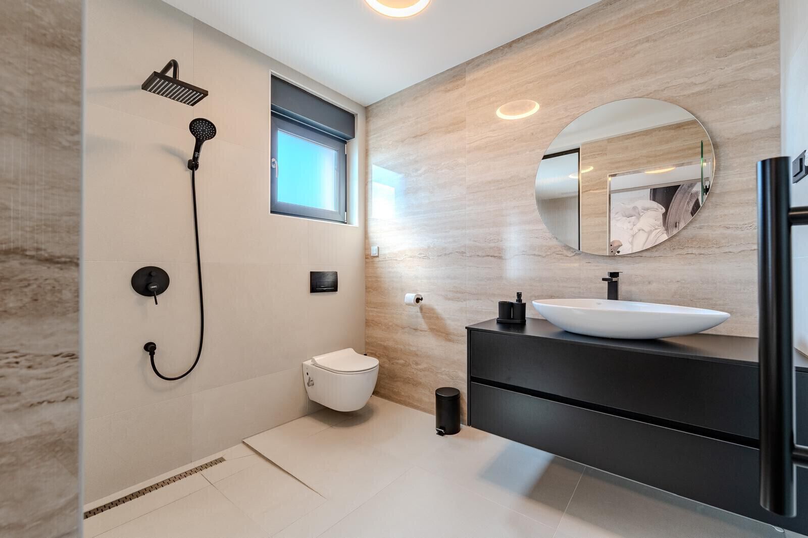 Ein modernes Badezimmer mit Dusche, Toilette und Waschtisch.
