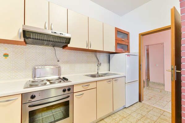 Una cocina equipada con estufa, horno, lavaplatos y refrigerador.