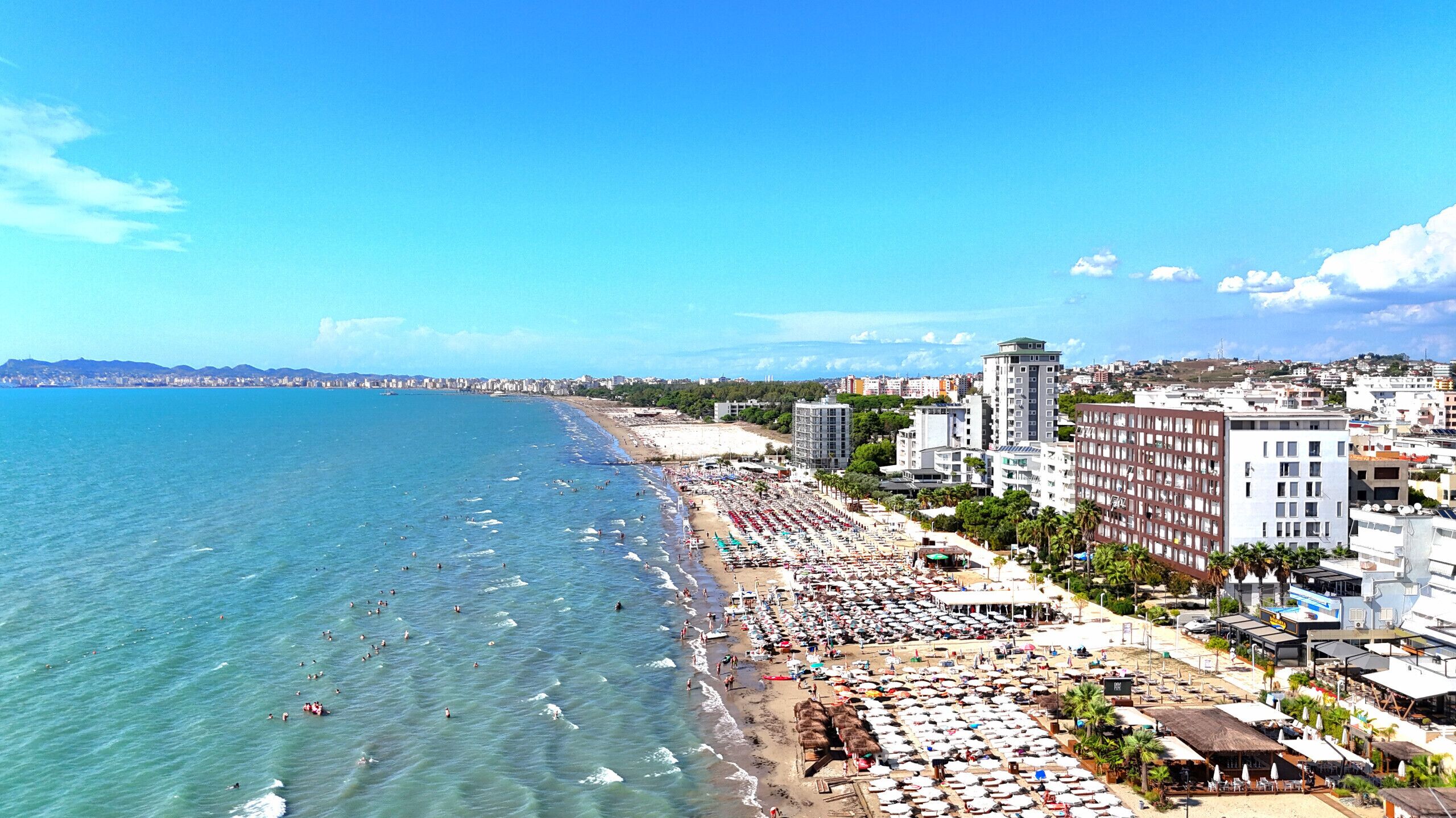 A beachside hotel with multiple buildings, a sandy beach, and the sea.