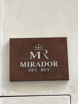 A sign with the text "MR MIRADOR DEL REY" on a brown background.