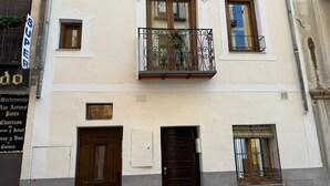 A building facade with a balcony, two windows, and a door. - Mirador Del Rey (Cuenca)
