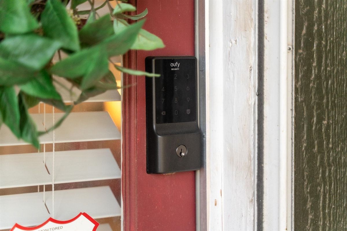 Puerta con teclado de seguridad y aviso que indica que está monitoreada.