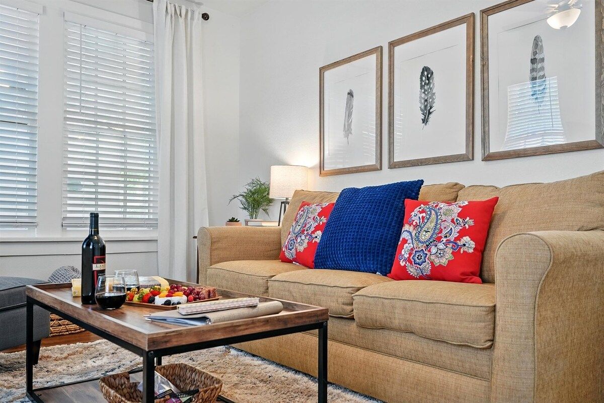 A living room with a sofa, a coffee table, a lamp, and framed artwork on the wall.