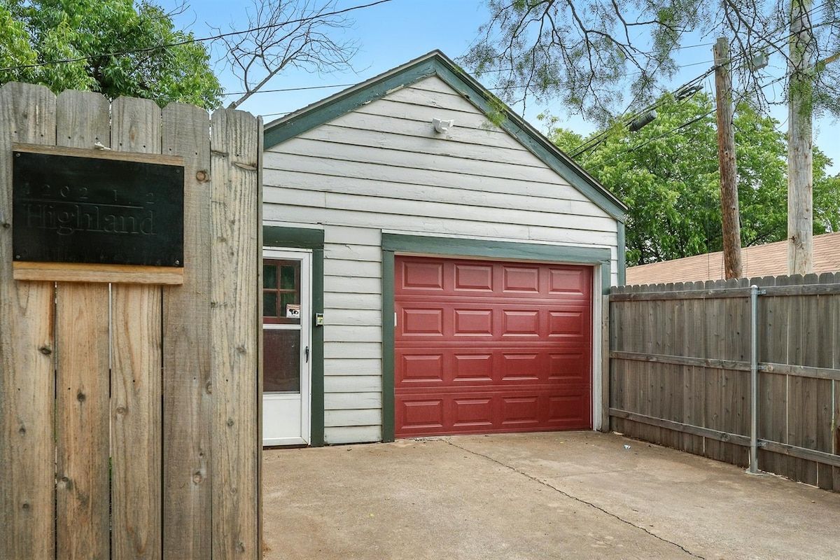 A single-story building with a red garage door and a white exterior.