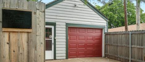 A single-story building with a red garage door and a white exterior.