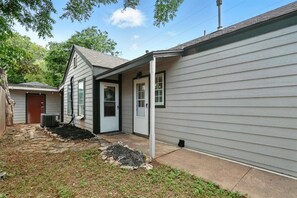 A residential property with a covered porch, a front door, and a small driveway.