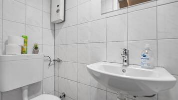 A bathroom with a toilet, a sink, and a mirror.