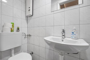 Un baño con inodoro, lavamanos y espejo.