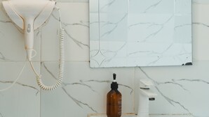 A bathroom with a white sink, a mirror, a hairdryer, and a soap dispenser. - Breflection Spa and Hostel (Zanzibar Town)