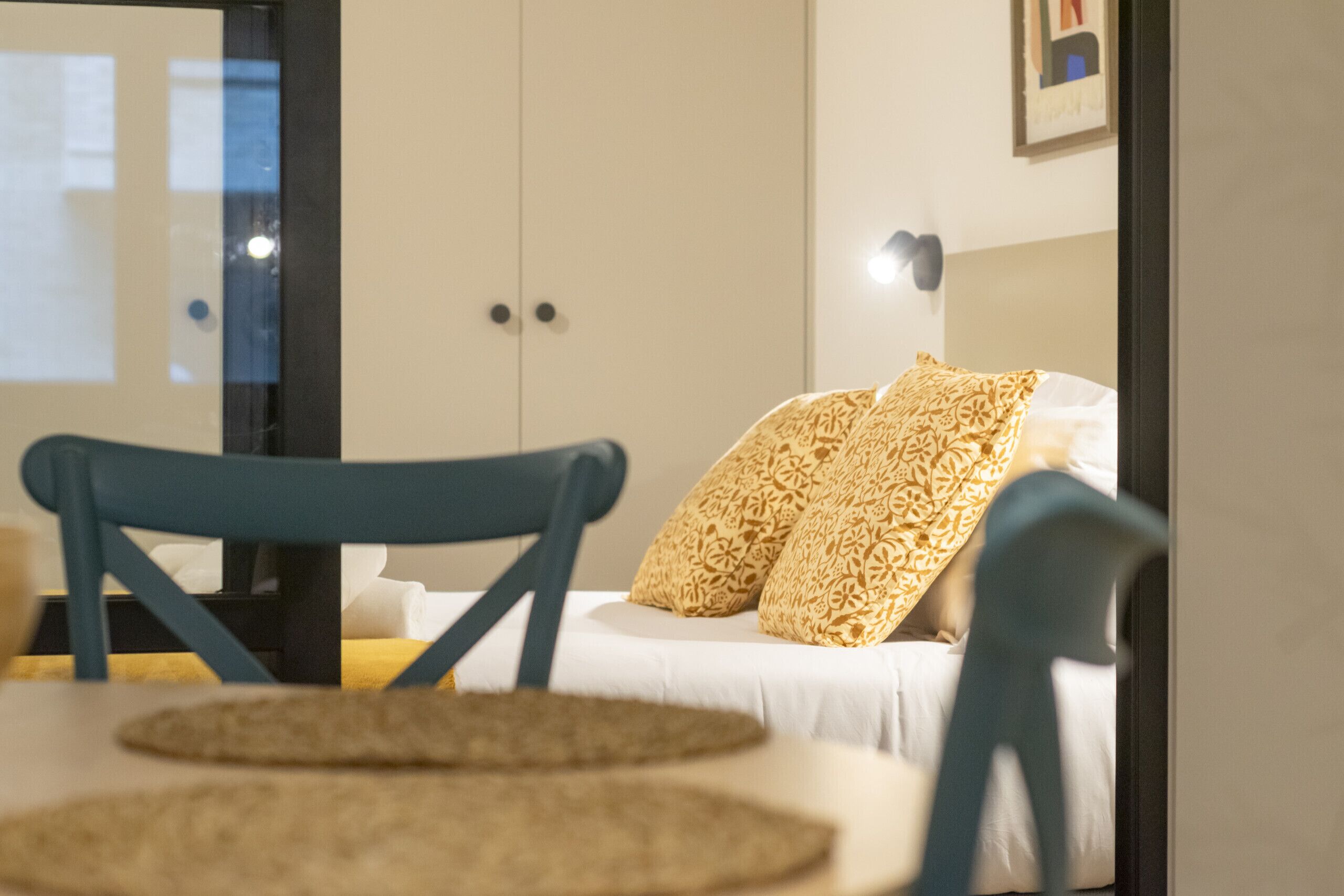 Une chambre à coucher avec un lit, deux oreillers, une table de chevet et une chaise.