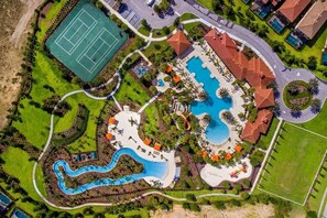 An aerial view of a resort with a large swimming pool, tennis courts, and a winding water feature. - 6 BR, 5 Ba, 11 Bed - Pool, Spa, Privately Managed (Davenport)