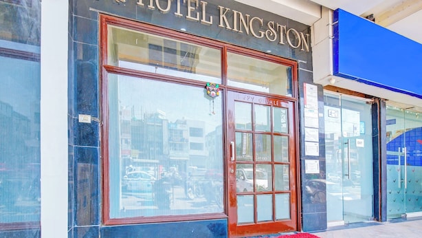 A hotel entrance with a large glass door, a red carpet, and a blue awning. - Hotel Kingstone Zirakpur (Zirakpur)