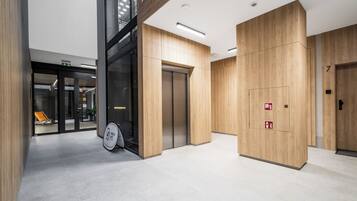 A modern interior with wooden paneling, a bike storage area, and an elevator.