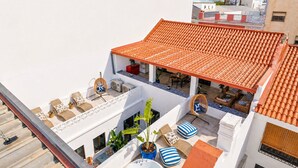 A rooftop terrace with a tiled roof, outdoor seating, and a hot tub. - City-center townhouse with patio, Stylish 3 bedroom townhouse near Portimão promenade, 15 mins to Praia da Rocha. Private unit in historic building with shared patio, AC in all rooms, fast Wi-Fi, and modern comforts. (Portimao)