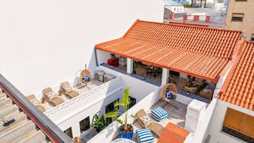A rooftop terrace with a tiled roof, outdoor seating, and a hot tub.