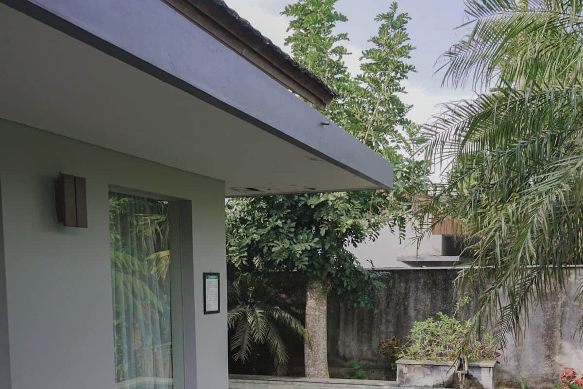 Une maison moderne dotée d’une piscine, d’un patio couvert et d’un jardin.