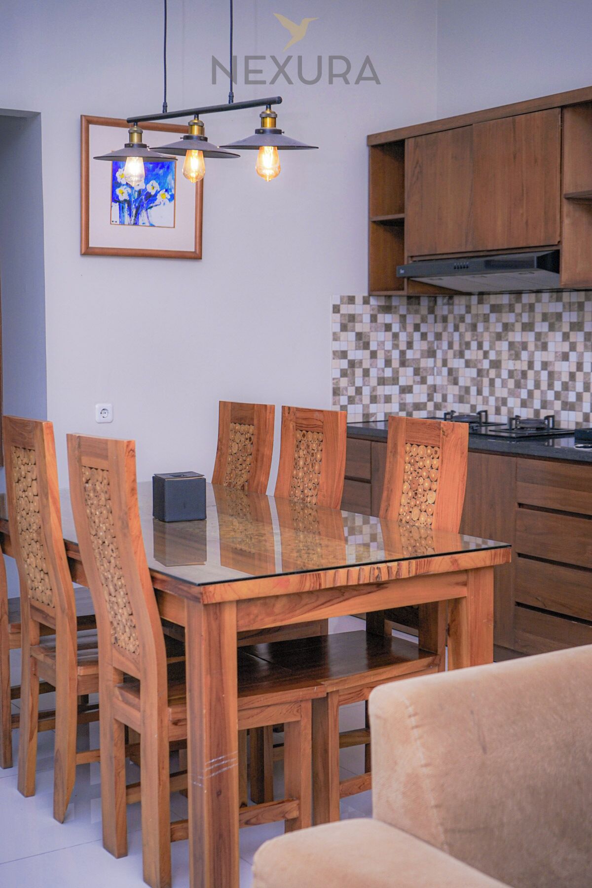 Eine moderne Küche mit Holzschränken, einer gefliesten Spritzschutzwand und einem Essbereich mit einem Glastisch und Holzstühlen.