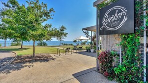 Een kustrestaurant met een bord waarop staat 'The Shore Restaurant & Cafe', met terras en uitzicht op zee.
