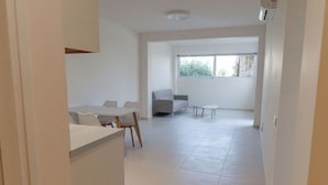 A spacious living area with a sofa, a dining table with chairs, and a small coffee table. - Phaedrus Living: Seaside Thalassa Cretan D101 (Platanias)