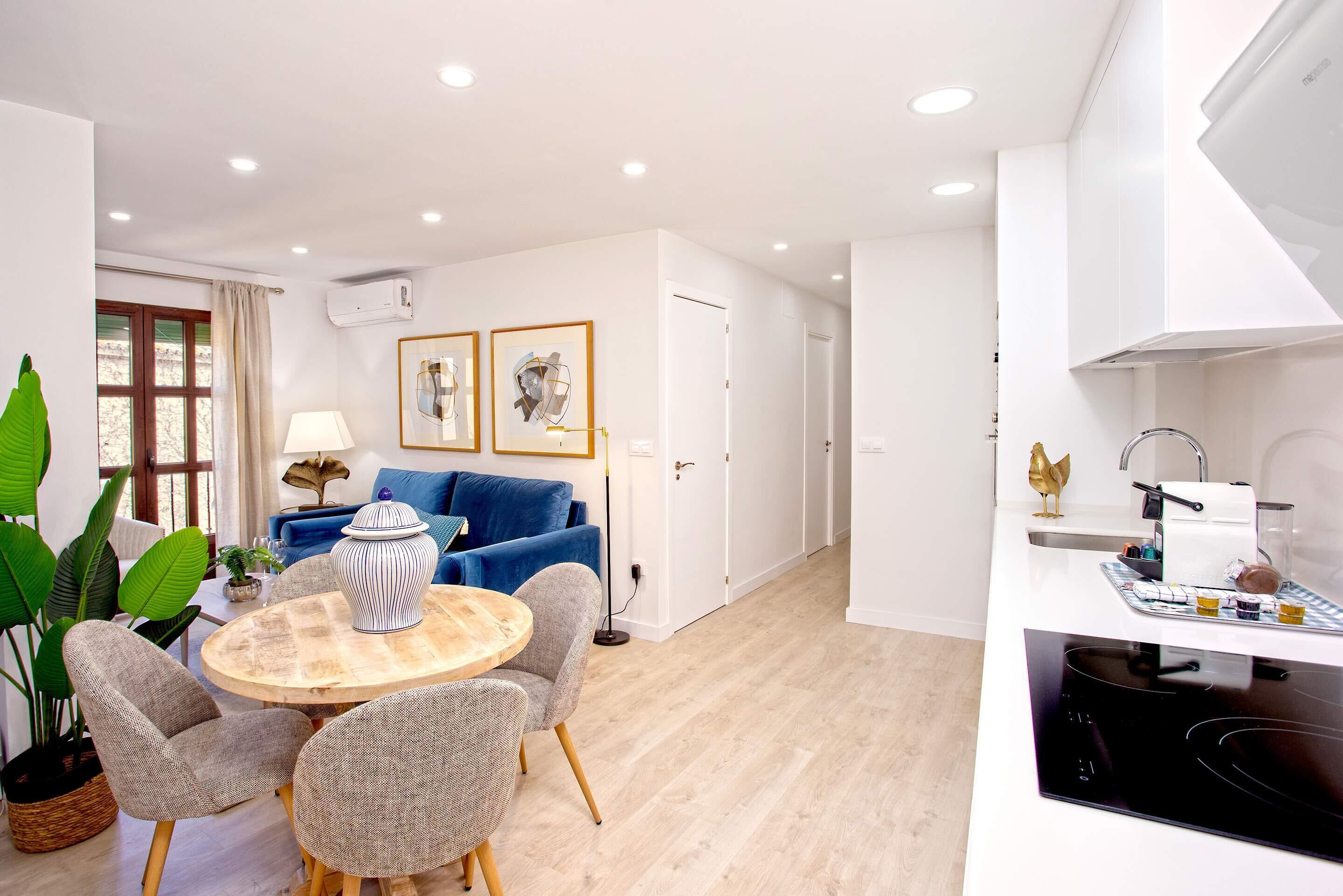 A modern apartment with a dining area, kitchen, and living space.