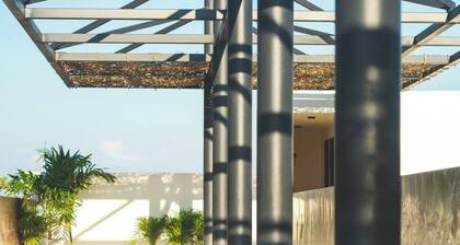 Stay in the heart of Tulum in a modern two-bedroom condo offering rooftop pools with Mayan ruin views, a lush garden patio, and walkable access to the area’s best dining and shopping.