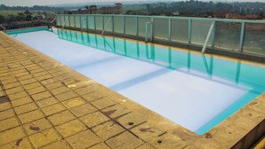 A swimming pool with a tiled deck and a glass barrier. - Marvelous studio apartment with swimming pool in vibrant Nairobi (Nairobi)