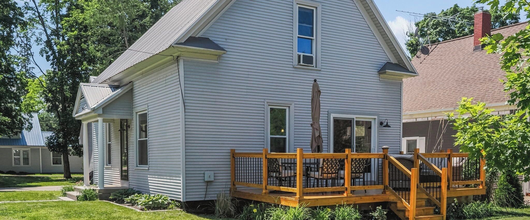 Ein zweistöckiges Haus mit Veranda und einer Holzterrasse.