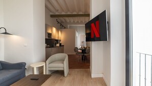 Una sala de estar moderna con un sofá, una mesa de centro y un televisor montado en la pared.