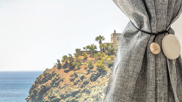 A bathroom with a view of a rocky coastline and a building on a hill. - The Libyan Coast House (Archanes-Asterousia)