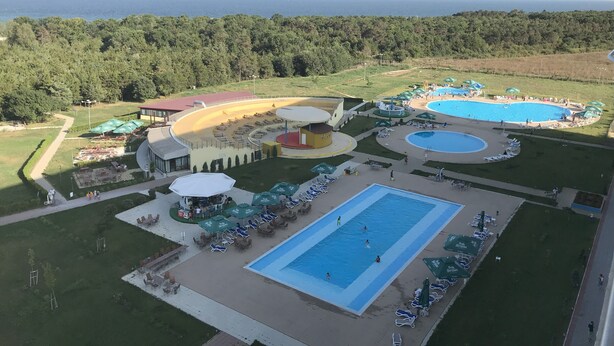 An aerial view of a resort with multiple swimming pools, sun loungers, and a large central pool. - Stay at Black Sea, Olimp Romania (Olimp)