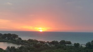 A sunset over a body of water with a small town in the foreground. - Stay at Black Sea, Olimp Romania (Olimp)